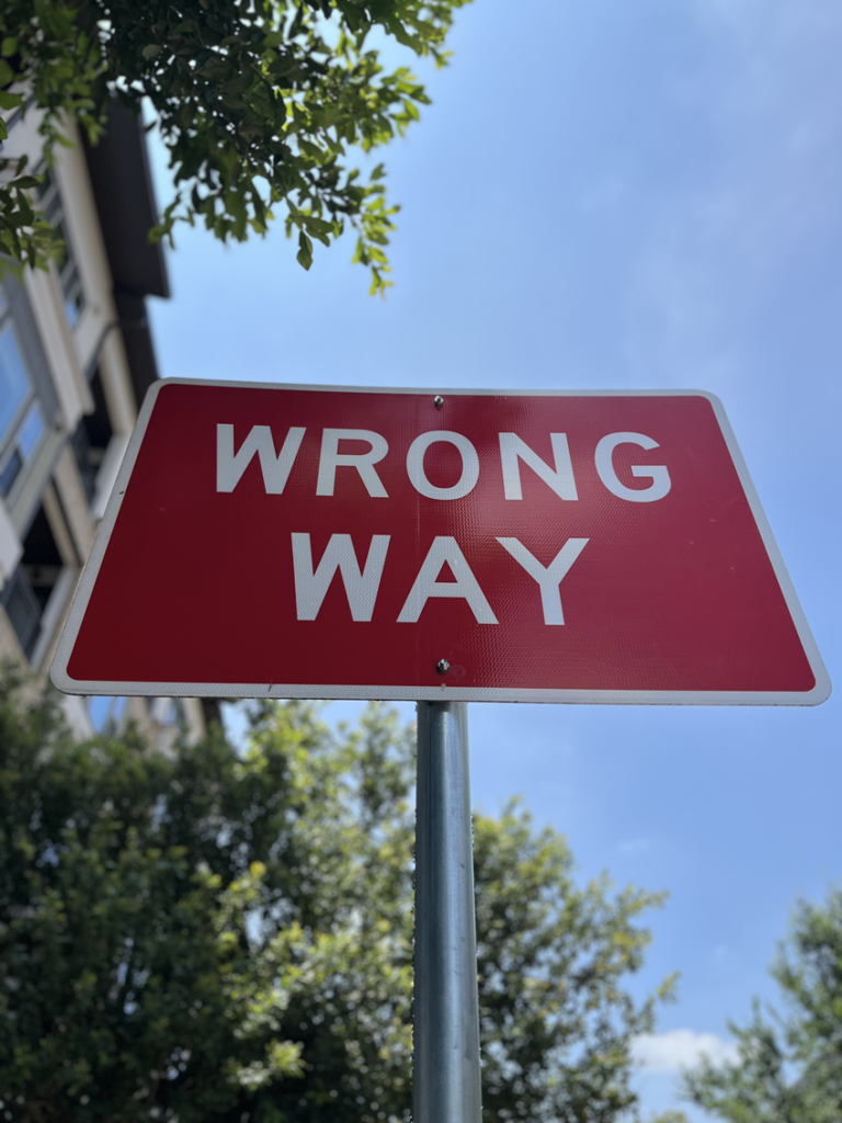 image of a red street sign which reads: Wrong Way